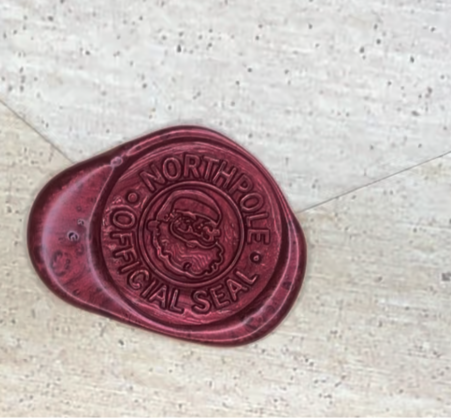 Red wax seal with 'North Pole" text on a textured surface